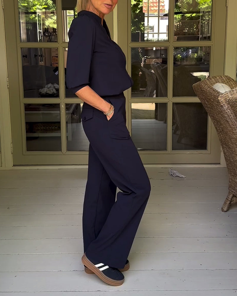 Stilfuld sort buksedragt med V-hals og lommer