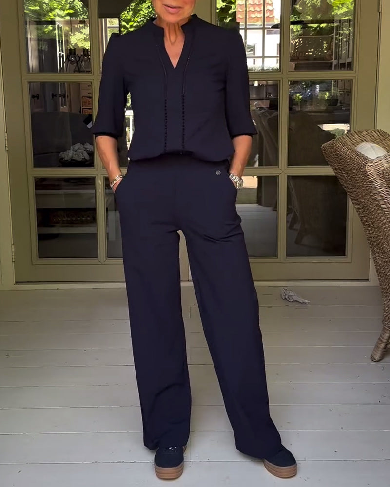 Stilfuld sort buksedragt med V-hals og lommer