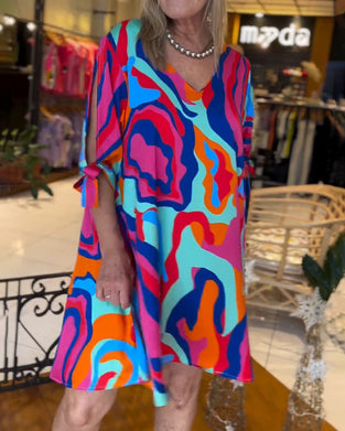 Løs kjole med farverigt print og rund hals