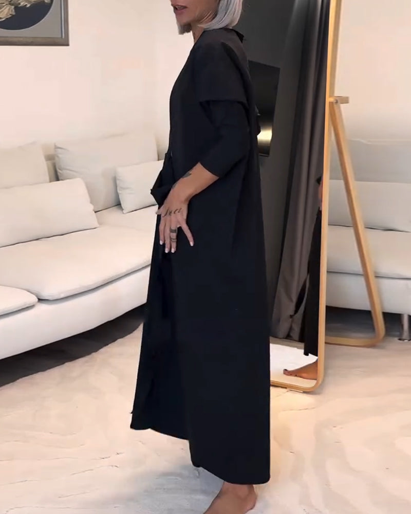 Stilfuld sort plisseret kjole med snøre og rund hals