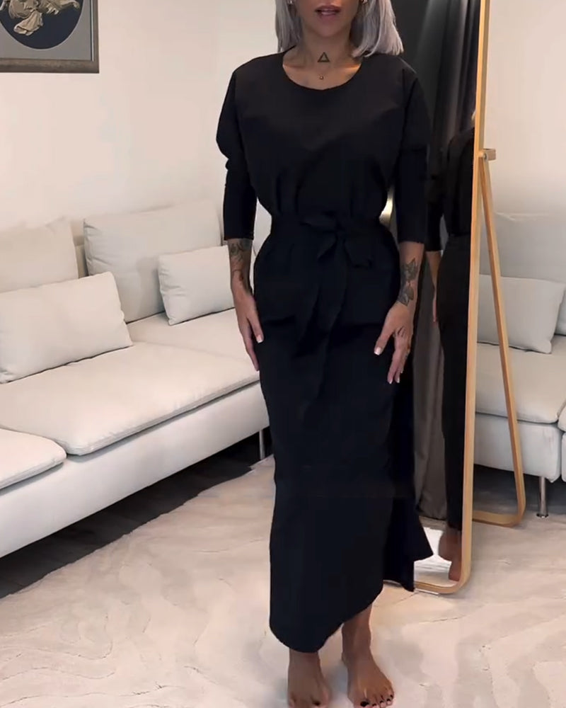 Stilfuld sort plisseret kjole med snøre og rund hals