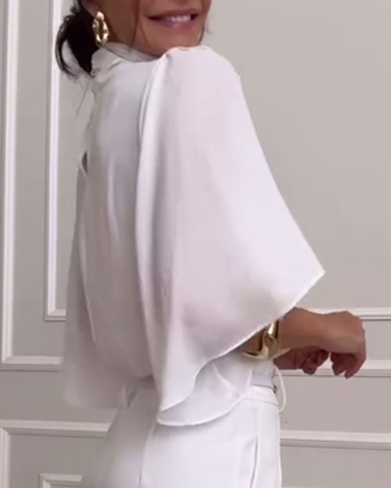 Ensfarvet bluse med høj krave med sommerfugleærmer