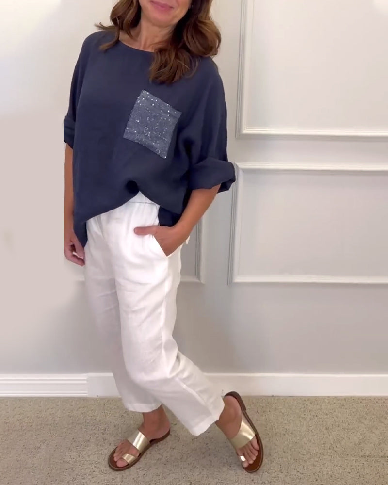 Rundhalset top med pailletdekoreret brystlomme